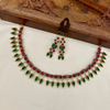 Jewelry set with necklace and earrings on a white cushion, wooden box in the background
